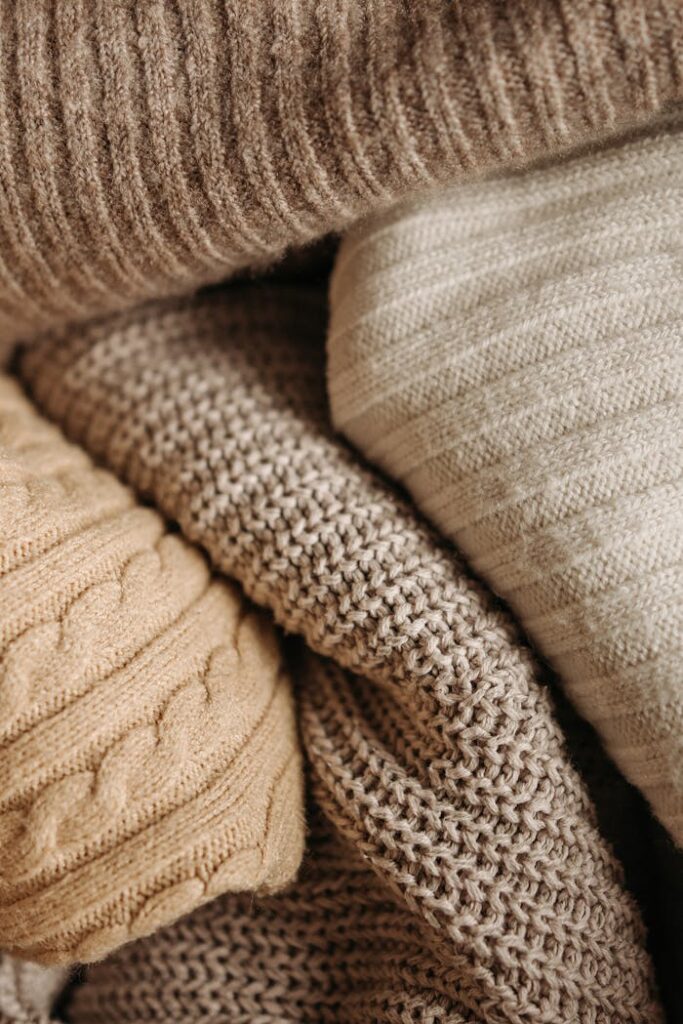 A detailed close-up of assorted knitted textiles showcasing different patterns and textures.